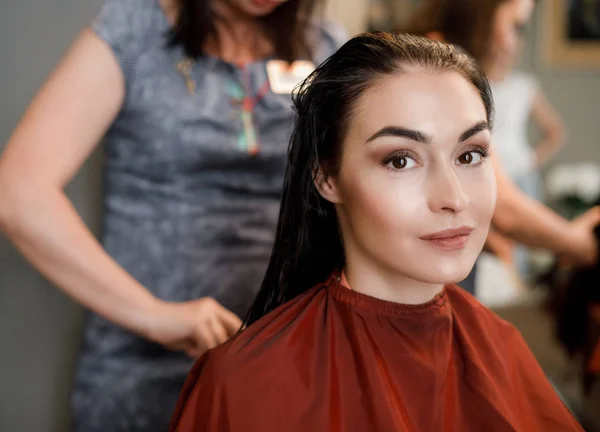 Parrucchiere pettinando i capelli del cliente nel salone di bellezza — Foto Stock