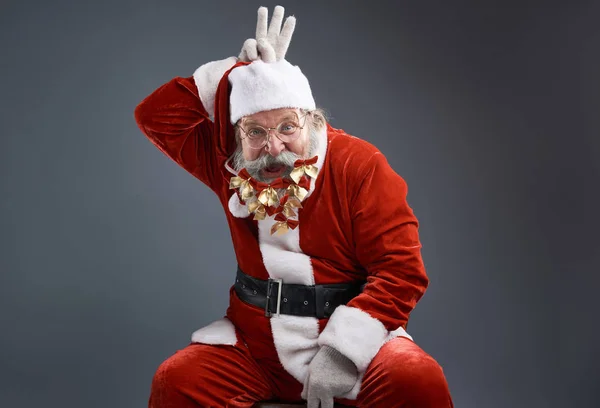 Cheerful Santa Claus with bows in beard showing three fingers above his head — Stock Photo, Image