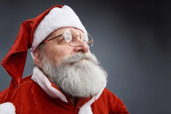 Vyrovnaná Santa Claus v brýlích pózuje na šedém pozadí — Stock fotografie