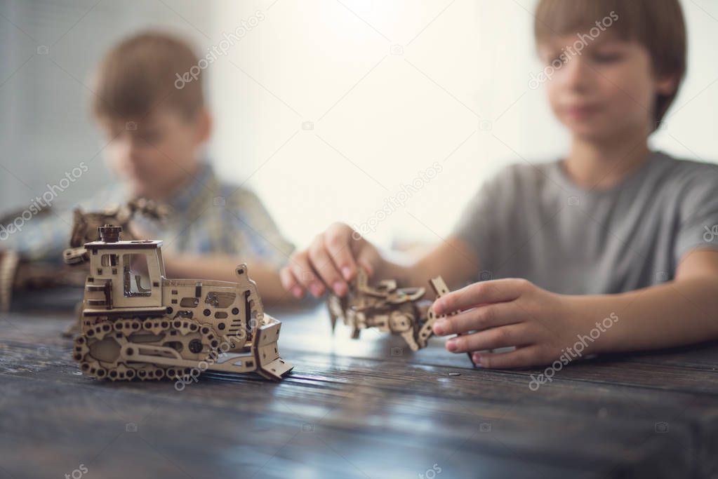 Close up of wooden model and two boys playing
