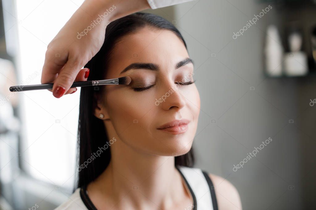 Visagist is doing classic eye makeup for lady