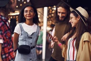 Süre gülümseyen çift Smartphone vasıl seyir konuşurken onların arkadaşları