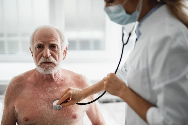 Doktor naslouchající pacienta dech a tep se stetoskopem — Stock fotografie