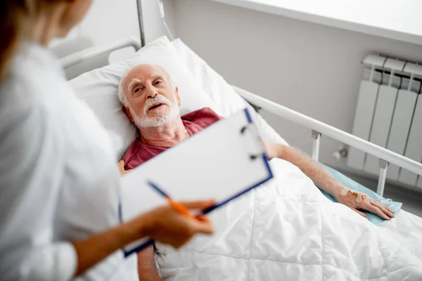 침대에 누워 있는 동안 의사와 얘기 하는 환자 — 스톡 사진