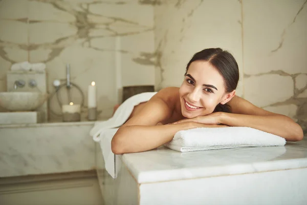 Gelukkige Dame op zoek naar jou en glimlachen terwijl liggend in de Hamam — Stockfoto