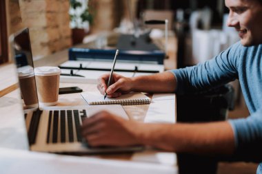 Genç öğrenci alan coworking içinde masada çalışıyor