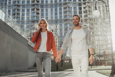 Neşeli genç ikili pitoresk sokaktan aşağı gidiyor