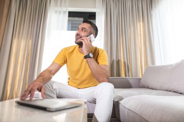 Çekici bir adam odada telefonla konuşan