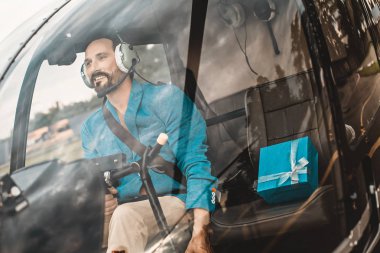 Helikoptere oturan ve güzel onun yanında mevcut olan sakin adam