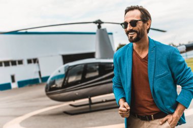 Helikopter duran ve gülümseyen rahat kıyafetler içinde mutlu adam