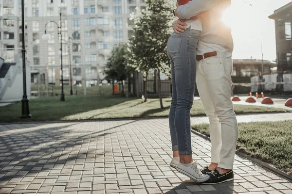 Молодой человек и женщина крепко обнимаются на улице — стоковое фото