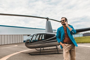 Helikopter smartphone ile yakın duran renkli giysiler içinde çekici adam