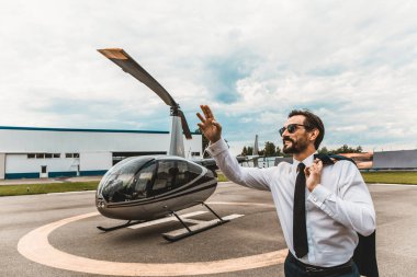 Neşeli adam kadar koyarak bir yandan helikopter yakın dururken