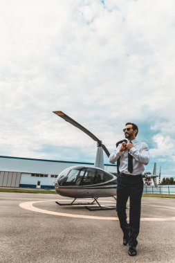 Helikopter platformu üzerinde yürüme ve gülümseyen sakin işadamı