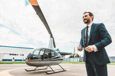 Helikopter duran ve gülümseyen çekici sakallı işadamı