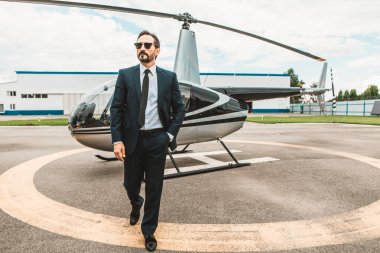 Gözlük takan ve helikopterden yürüyüş emin işadamı