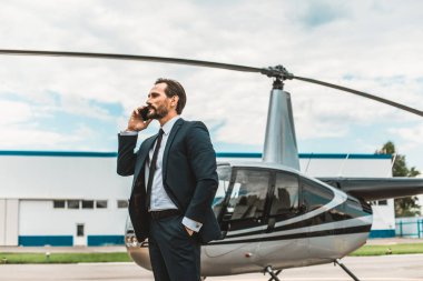 Helikopter yakın dururken telefonda konuşan sakin adam