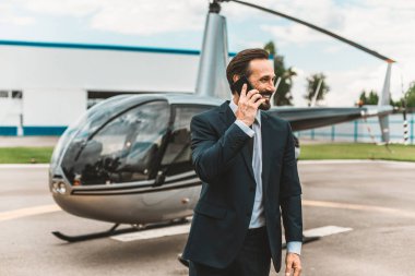 Şık elbiseli helikopter değil çok uzak duran ve telefonda konuşurken mutlu duygu duygusal adam