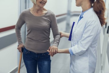 Kadın doktor yaşlı Bayan elle destekliyor