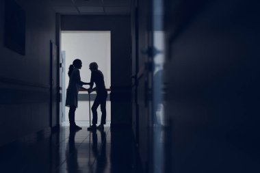 Kadın doktor Bayan koridorda kamışı ile yardım