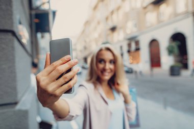 Alışveriş çanta selfie sokakta yapımı ile gülümseyen kadın
