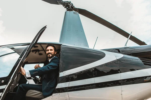 Alegre empresario sonriendo mientras abre las puertas del helicóptero — Foto de Stock