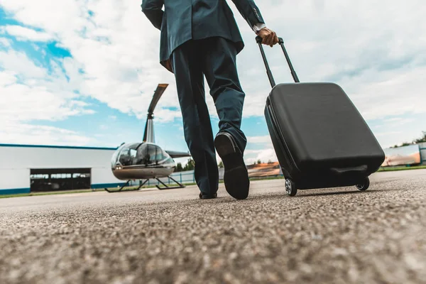 Primer plano de un hombre elegante llevando su equipaje en la plataforma del helicóptero — Foto de Stock