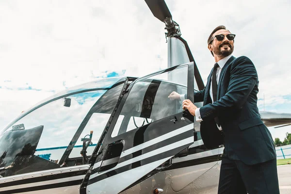 Hombre feliz de pie cerca del helicóptero y mirando emocionado — Foto de Stock