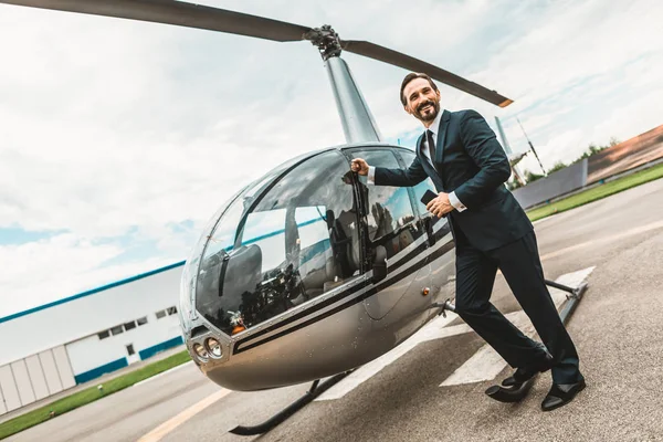 Feliz hombre poniendo su puño en el helicóptero y sonriendo — Foto de Stock