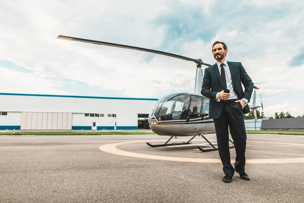 Kendine güvenen işadamı duran helikopter yakınındaki gülümseyen