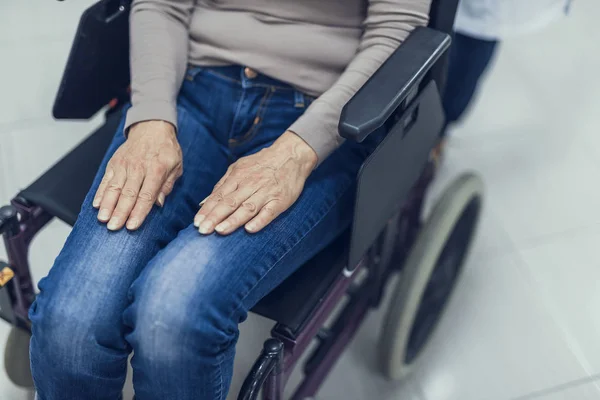 Зрелая дама сидит в инвалидном кресле в больнице — стоковое фото
