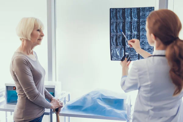 Female surgeon is analyzing radiography in the hospital — Stock Photo, Image