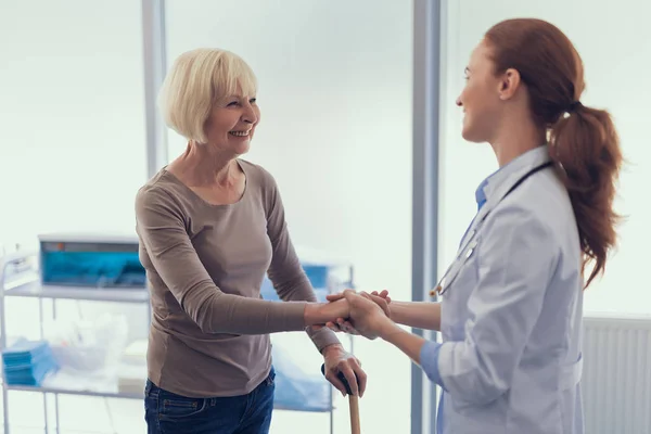 Amistoso cirujano está saludando a mujer madura en el hospital — Foto de Stock