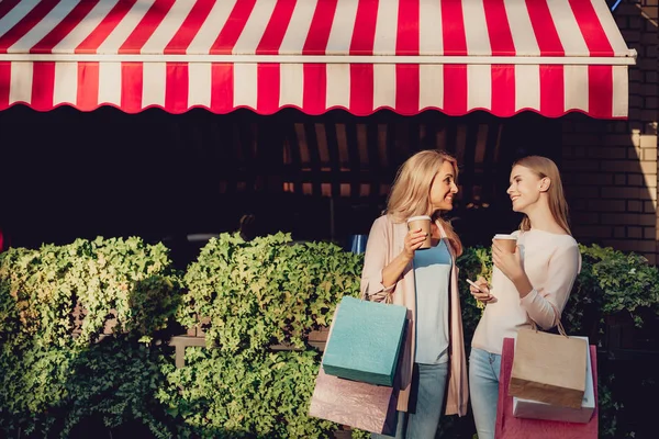 Chica encantadora charlando con la madre en la calle en el día soleado — Foto de Stock