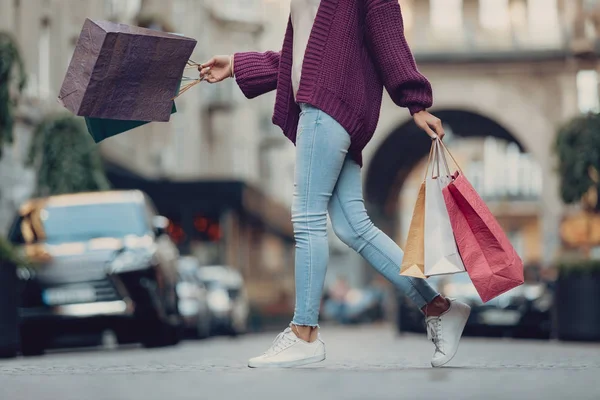 Young lady in blue jeans walking on the street — Stock Photo, Image