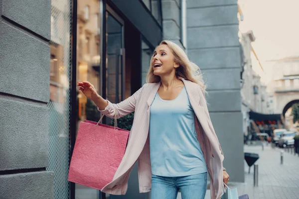 Mooie midden leeftijd vrouw haast te kopen van kleding in de winkel — Stockfoto