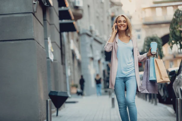 Mooie vrouw praten op mobiele telefoon tijdens het lopen op straat — Stockfoto