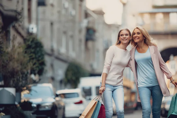 Счастливая женщина средних лет и ее дочь идут по улице — стоковое фото