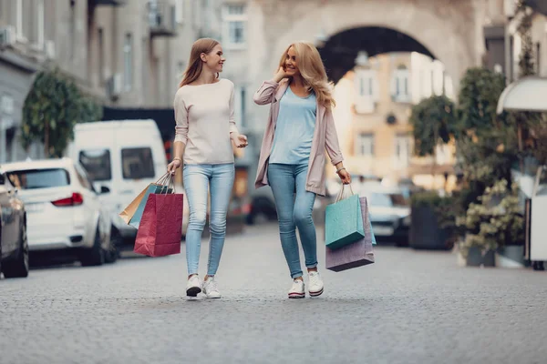 Vackra medelålders kvinna och hennes dotter som går på gatan — Stockfoto