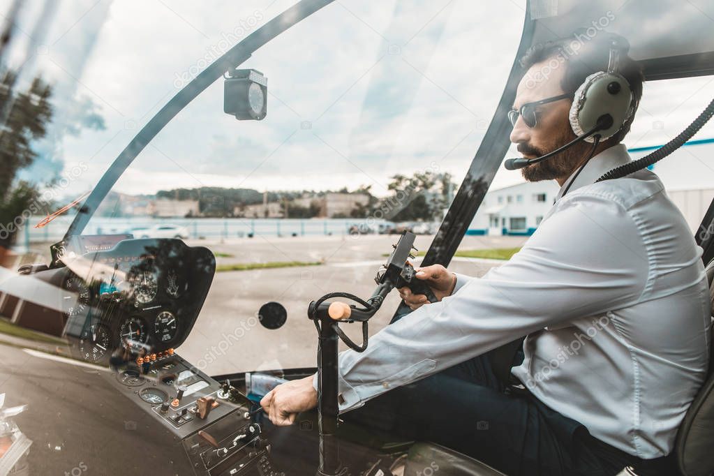 Calm pilot sitting in the cabin while working alone