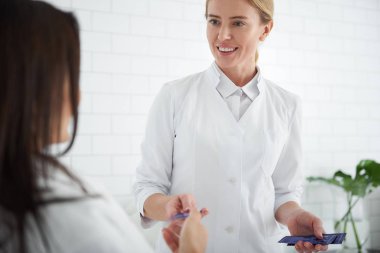 Genç kadının yüz kremi örnekleri vererek dostça güzellik uzmanı