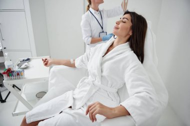 Genç Bayan intravenöz damla düzenleyen Doktor dinlenme