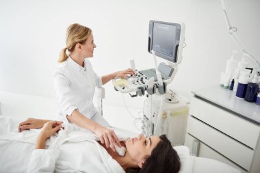 Tiroid ultrasonu testi genç kadın için yaptıkları doktor gülümseyen