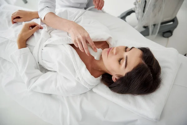 Mujer joven acostada en la cama durante el examen médico — Foto de Stock