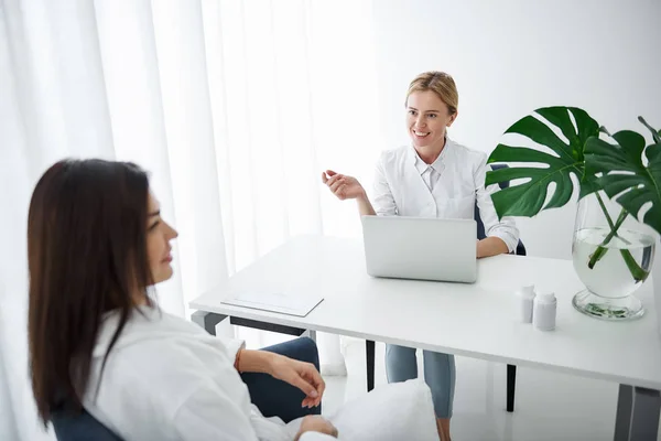 Kosmetolog diskuterar skönhetsbehandlingar med ung dam — Stockfoto