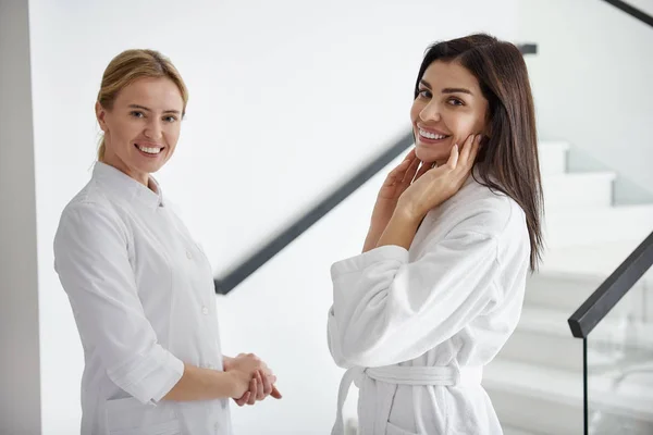 Tânăra doamnă și cosmetolog stând în fața scărilor la salonul de înfrumusețare — Fotografie, imagine de stoc