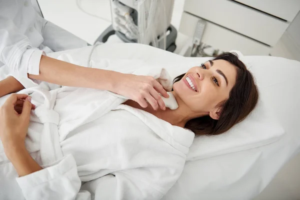 Красивая женщина получает ультразвук щитовидной железы в оздоровительном центре — стоковое фото