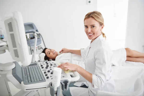 Läkare använder ultraljud scanner samtidigt undersöka sköldkörteln av ung kvinna — Stockfoto