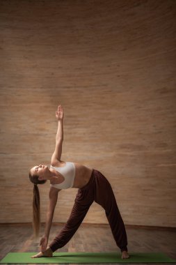 Defolmak üçgen poz yoga sınıfı pratik sakin genç bayan