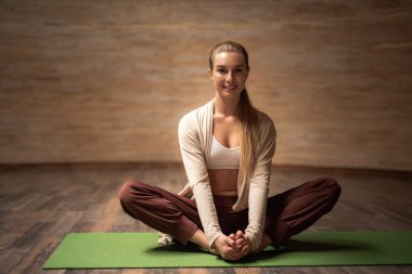 Gülümseyen ve ayaklarının lotus poz dokunmadan güzel Bayan